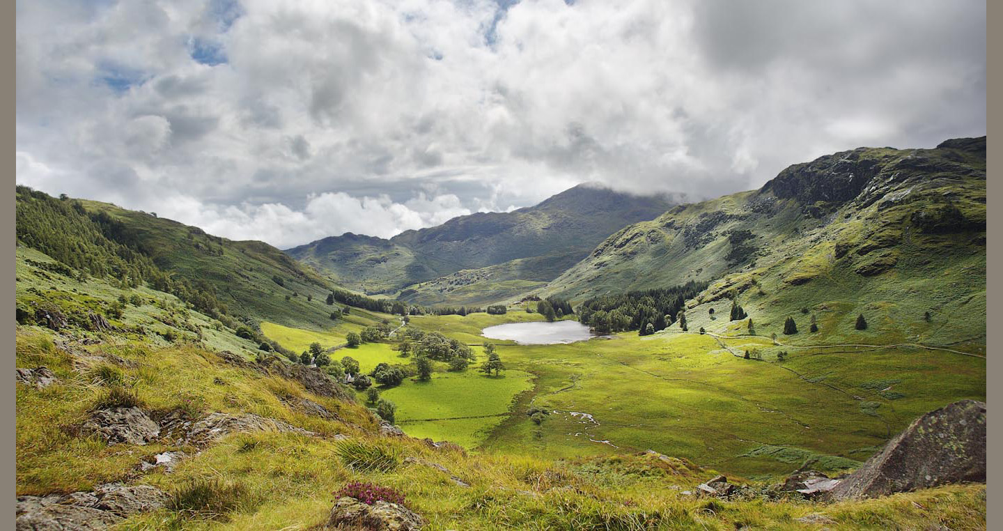 Mountains meadows and clouds encircle Blea Tarn